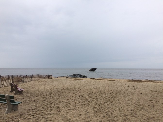 Photograph of beach on cloudy day, wreck of Atlantus is background