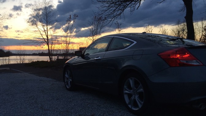 Gray Honda Accord in front of sunset sky.
