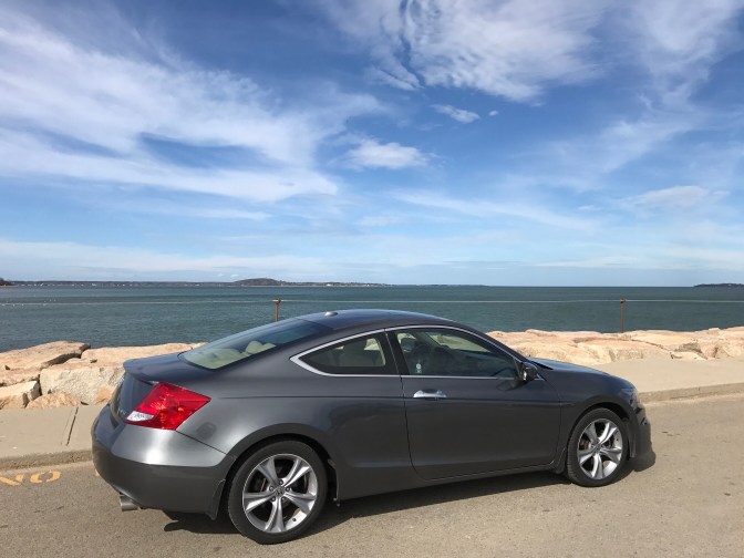 Gray Honda Accord in front of Massachusetts Bay shoreline.