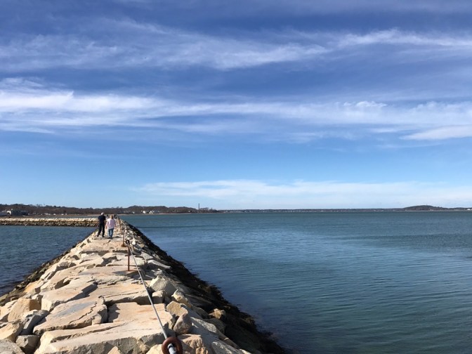 Plymouth Breakwater jetty, with people walking on it.