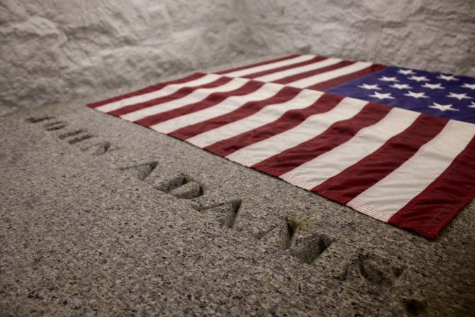 Tomb of John Adams with US flag at head of tomb.