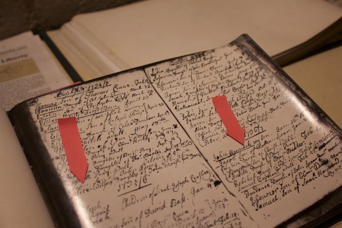 Copy of the church's baptismal registry, with arrows on page pointing to names of John Adams and John Hancock.