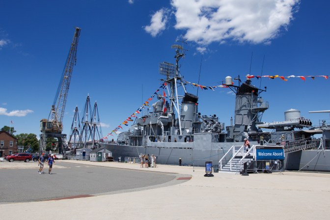 USS Cassin Young at dock. A gantry crane is beside it.