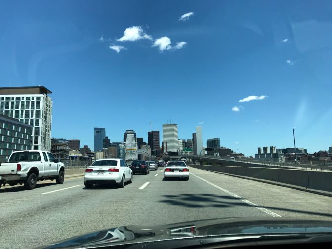 View of the Boston skyline, with traffic in the foreground.