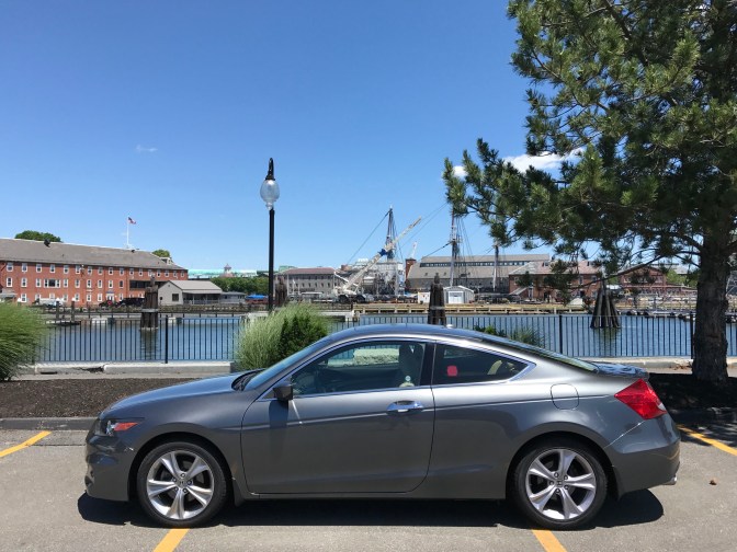 Honda Accord in foreground, masts of USS Constitution visible in distance.