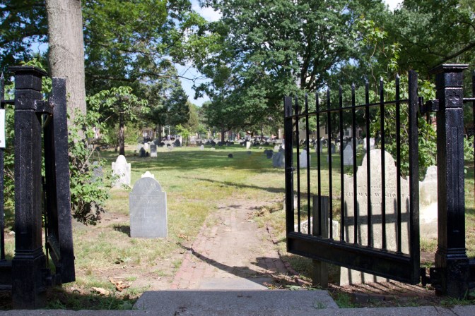Entrance to Cambridge Burial Grounds. A gate is in the foreground.