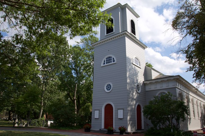 View of Christ Church in Cambridge. A tree branch is in the foreground.