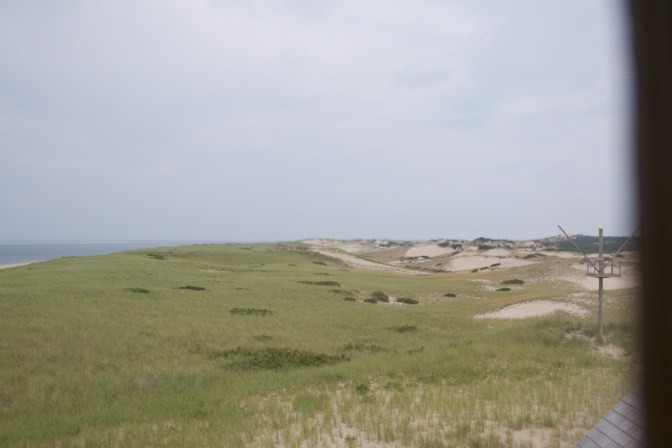 View of the dunes and the sea, through a window.
