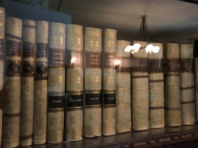 Books from the writer Dante, on a bookshelf.