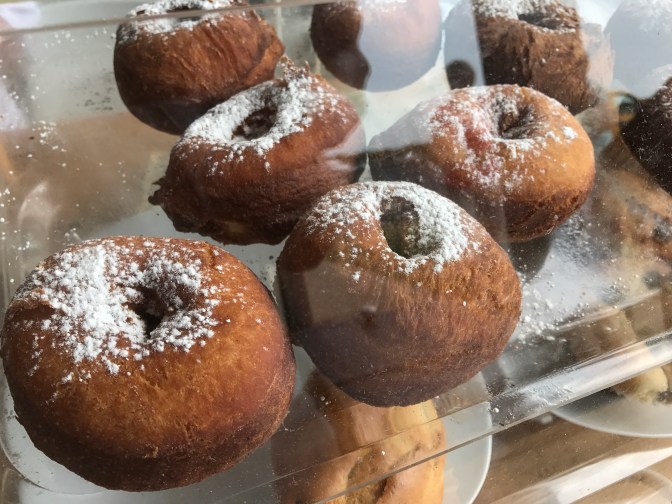 Buttermilk potato donuts in a plastic container.