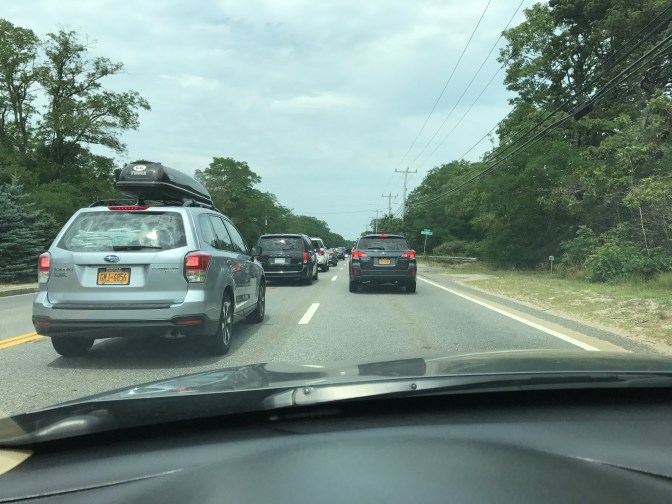 View from behind the wheel of two lanes of bumper to bumper traffic.