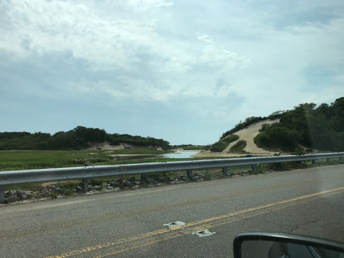 View of dunes from the side of the road. Car mirror is in the foreground.