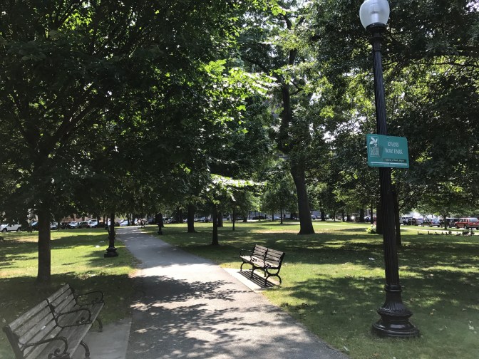 Evans Way Park near the museum. Benches are on either side of a central path.