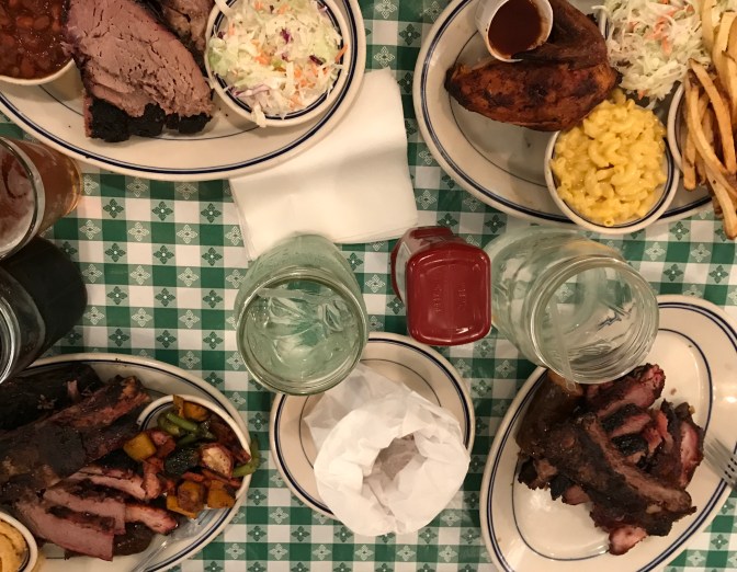 Table with four entrees including ribs, brisket, and chicken.