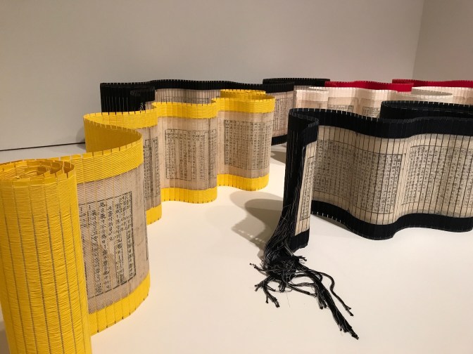 Scrolls of paper with Korean writing, with yellow and black borders.