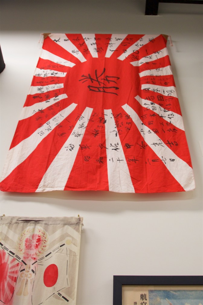 Japanese flag signed by captain and crew of a submarine, with the word "victory" in Japanese in the middle.