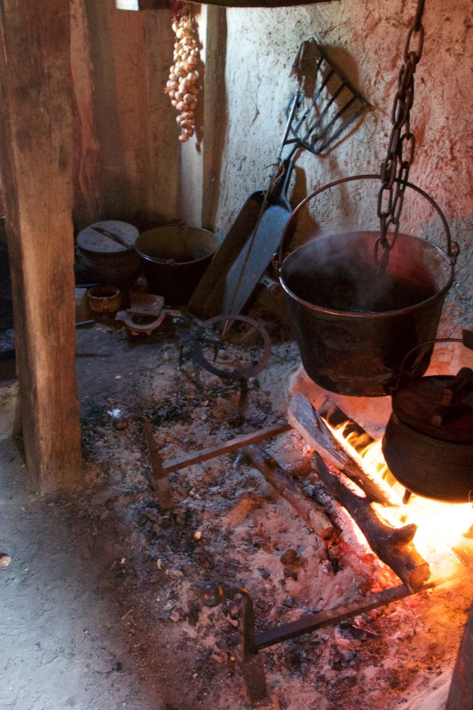 Open flame kitchen with two pots above the fire.