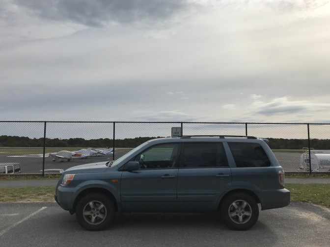 2007 Honda Pilot parked in front of airport fence.