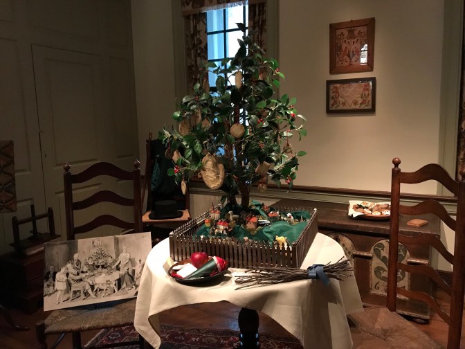 A small Christmas tree on a table is decorated with Christmas cookies.