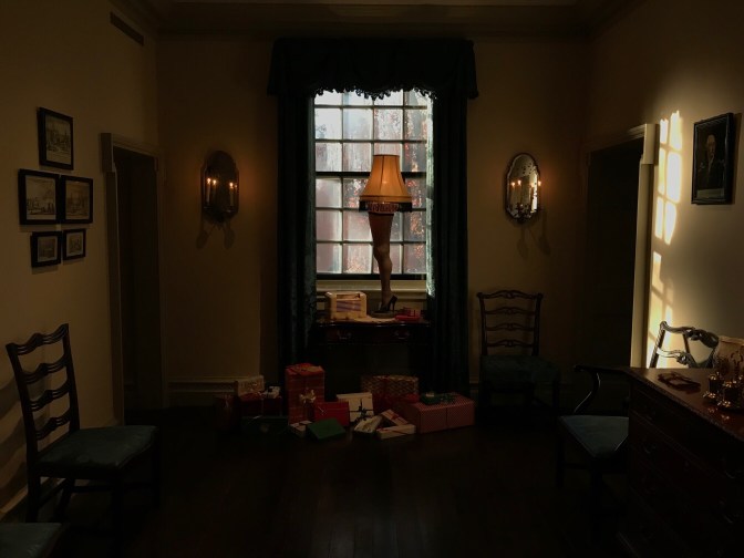 Leg lamp on a table by the window. Presents are on the floor.