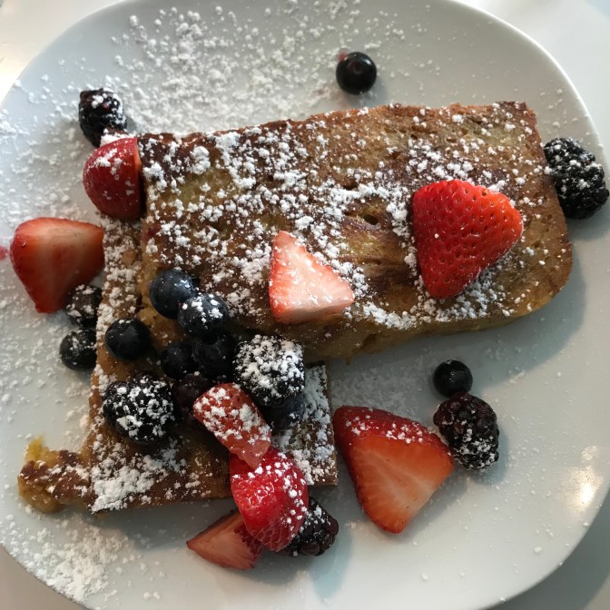 Bread pudding French Toast, with strawberries, grapes, and blackberries on top.