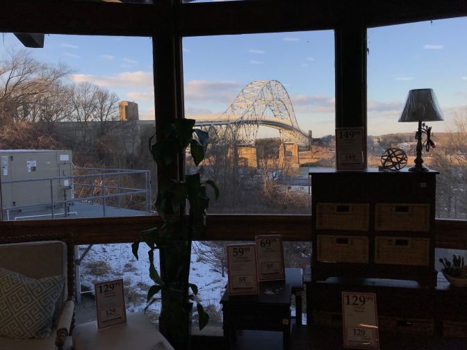 View of the Bourne Bridge from the interior of the store, looking through a window.
