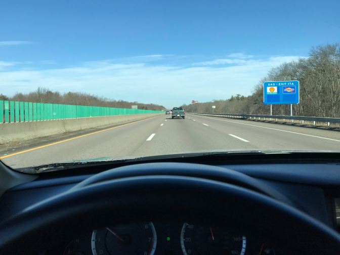 View of highway from behind wheel of car.