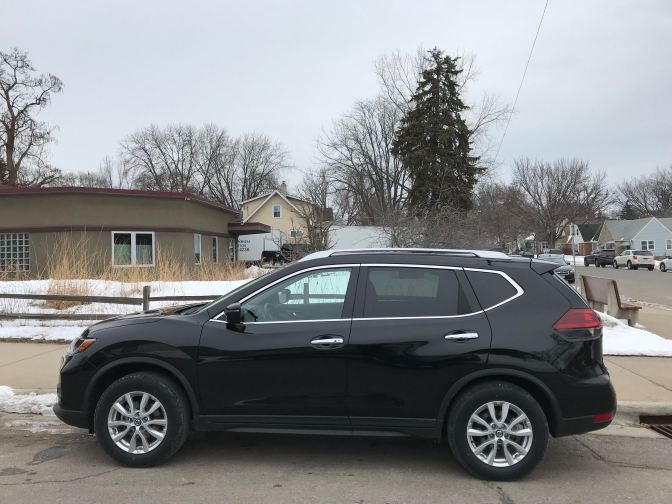 2017 Nissan Rogue, black, parked along side street.