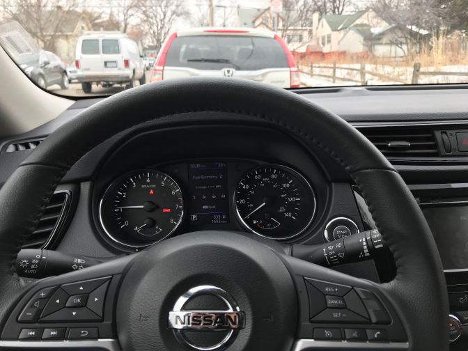 View of steering wheel and dashboard of Nissan Rogue.