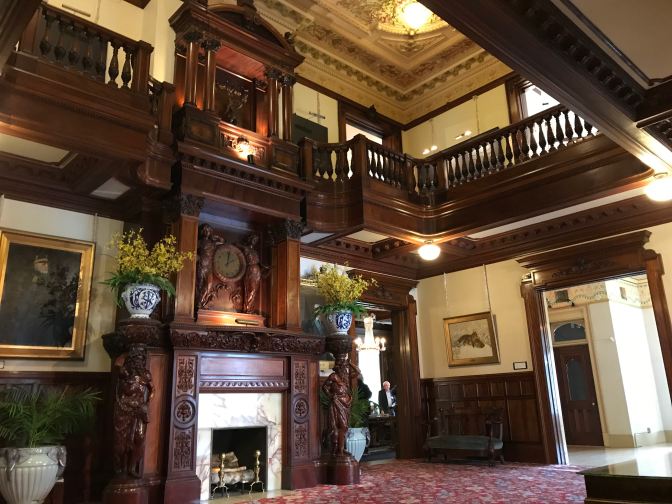 Grand Hall, with balcony on second floor and fireplace.