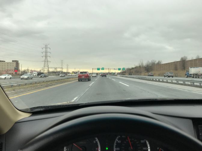View of New Jersey Turnpike from behind wheel of car.
