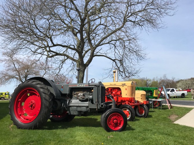 Tractors in a line at a car show.