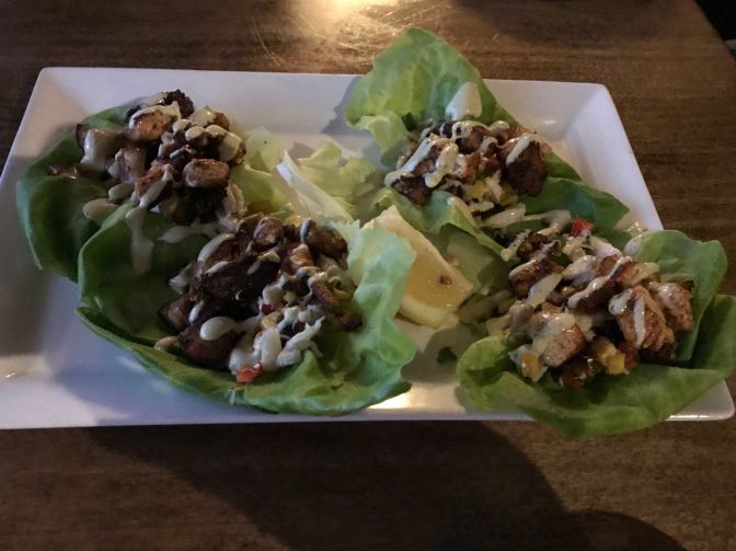Lettuce wraps on a white plate.