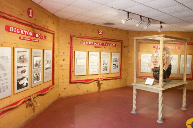 An octagonal room holding a model ship and wall displays.