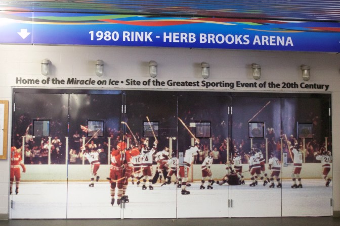 Doors to the Herb Brooks Arena, with a wall-size photo of the US team celebrating its win on the entrance doors.