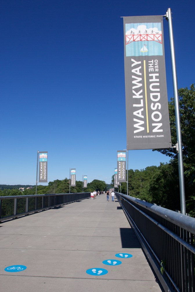View of Walkway Over the Hudson, with flags along the bridge that say WALKWAY OVER THE HUDSON.