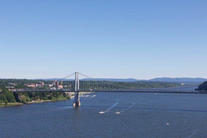 View of the Mid-Hudson Bridge, with boats in the water below the bridge.