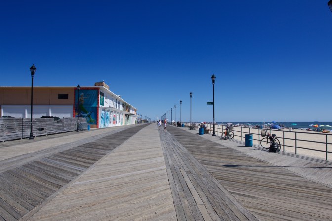 View of the boardwalk, facing north. A building covered in murals is on the left.