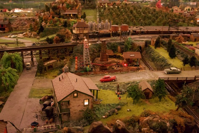 Oil drilling site, with four derricks in center of photo.