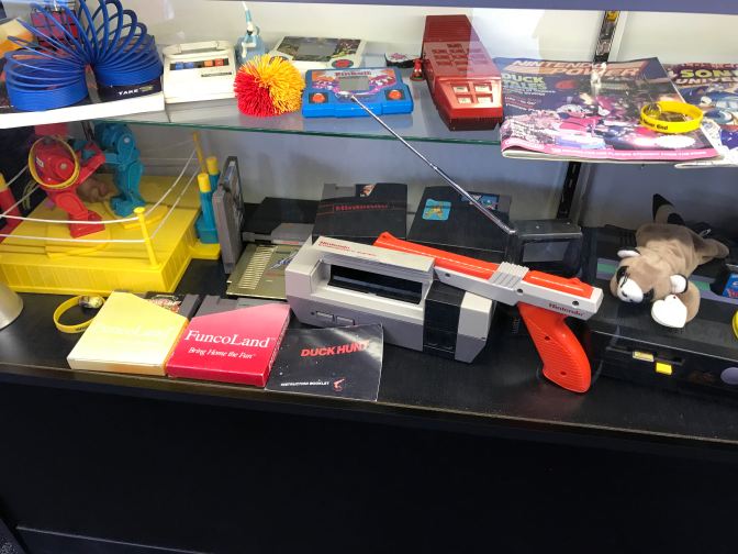 Display including copies of Nintendo Power, a Nintendo Entertainment System, Robot Boxing, and stuffed animals.