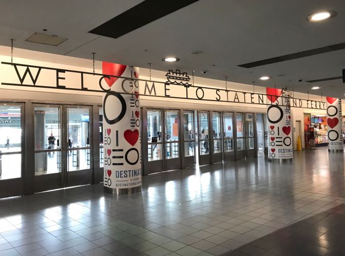 Entrance to Staten Island Ferry Terminal. A sign above the terminal says WELCOME TO STATEN ISLAND FERRY.