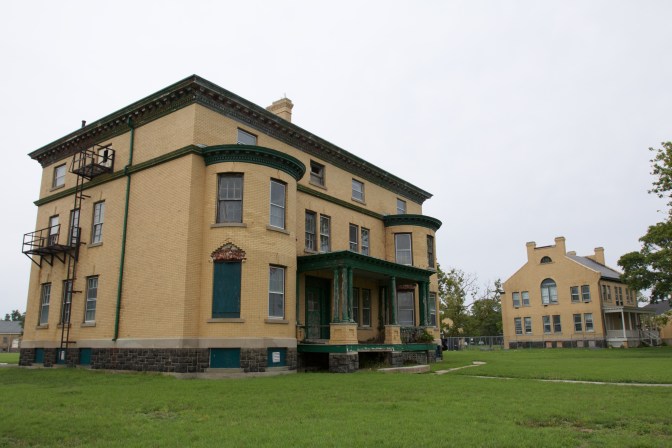 Two large, three story buildings. A large lawn surrounds each one.