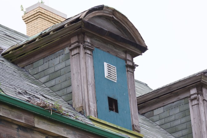 Boarded-up window on 3rd floor of house.