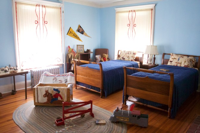 Child's bedroom with two beds. Toys are on the floor.