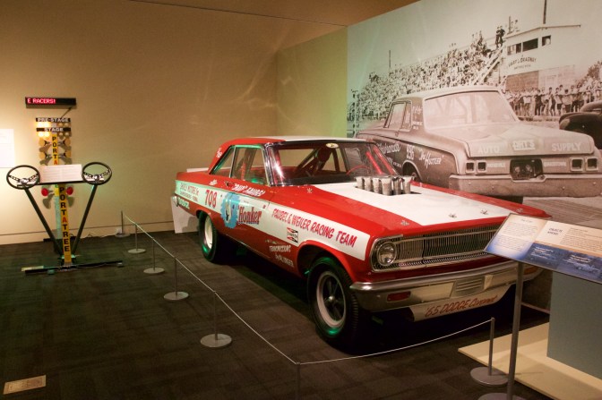 1965 Dodge Coronet funny car in red and white. A drag racing "Christmas Tree" is on the left of the image.