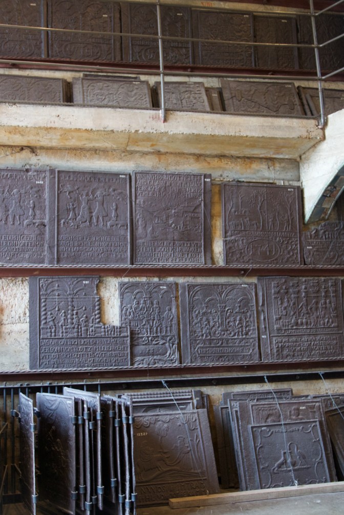 Exhibit of stove plates, in five rows from floor to ceiling.