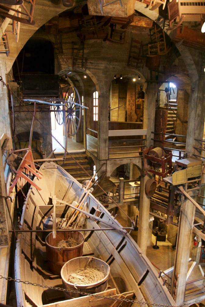Objects, including a carriage and a rowboat, hanging from the walls around the central atrium.