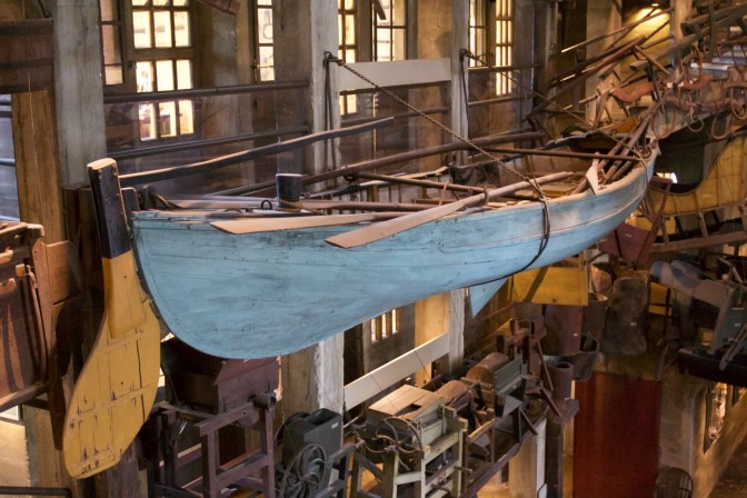 Whaleboat suspended from railings around atrium.