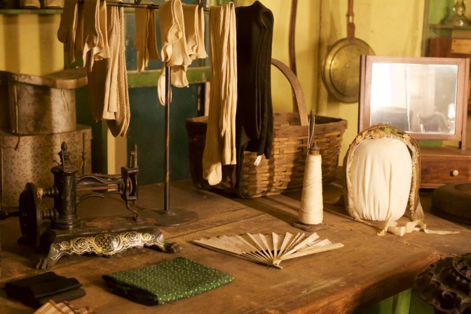 Items for sale in country store, including sewing machine, socks, and a fan.