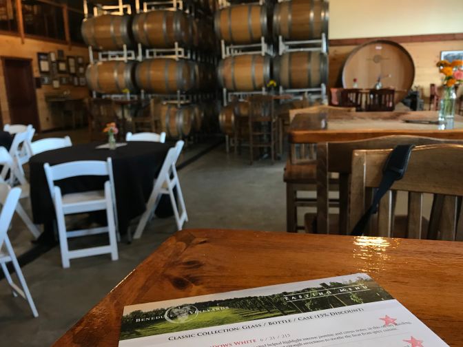 View of wine tasting room from a table. A wine menu is on the table in the foreground.